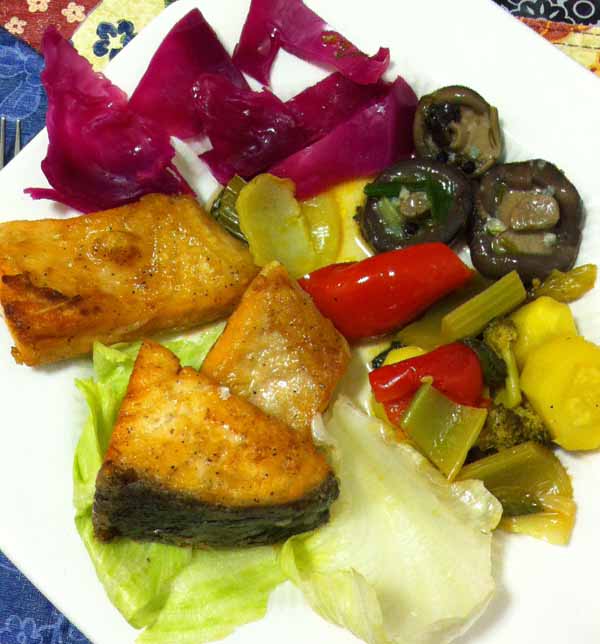 Жаренный лосось с тушенными овощами и соленьями.